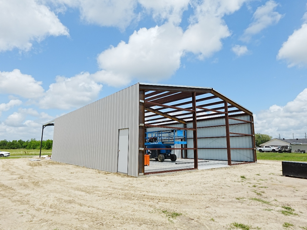 Red iron steel building frame erected on a concrete slab